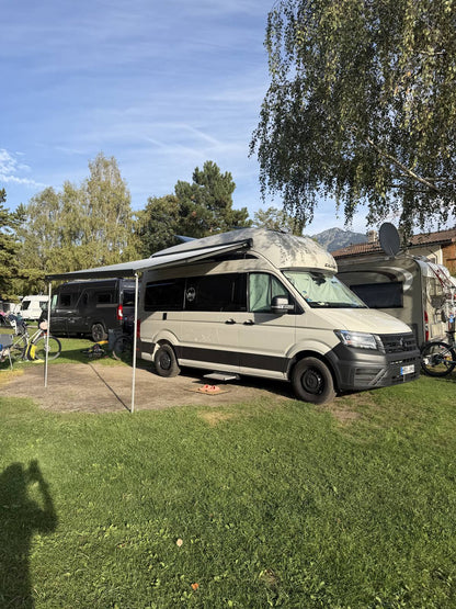 Grand California mit ausgefahrener Markise auf dem Campingplatz