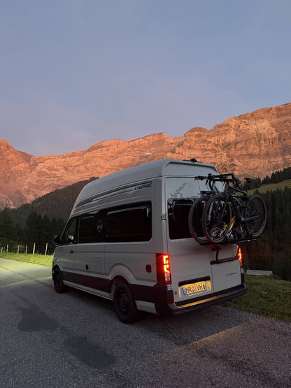 Grand California mit Fahrradträger im Abendrot der Berge